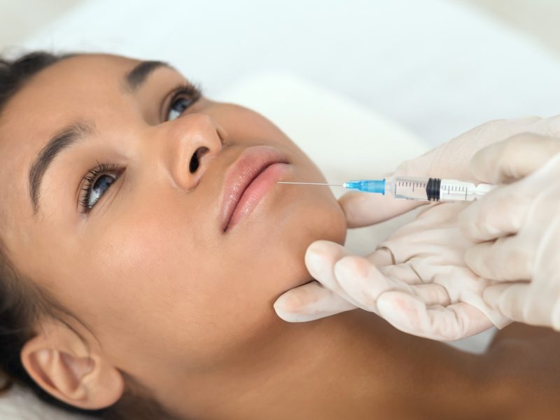 Close-up of aesthetic procedure on face for black lady Close-up of aesthetic procedure on face for black lady