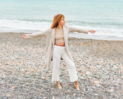 Happy curly woman on the beach